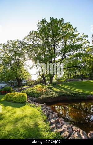 Summer landscape with artificial small waterfall in park. Stock Photo