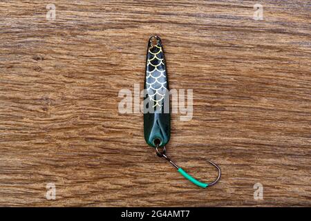 Old fishing lure made of stainless on the old wooden table close-up Stock Photo