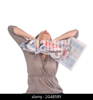excited and emotional young woman ripping up a printed newspaper studio shot on white background Stock Photo