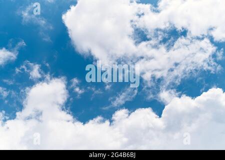 White clouds float across the bright blue sky. Close-up Stock Photo