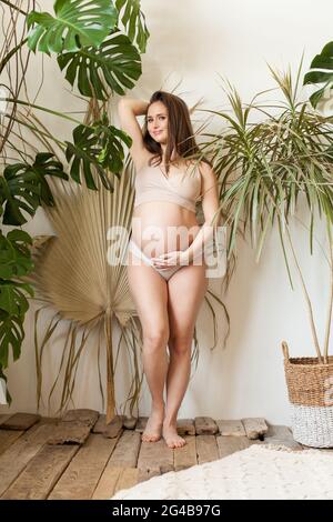 Beautiful fit pregnant woman wearing sport swimsuit on nature background Stock Photo