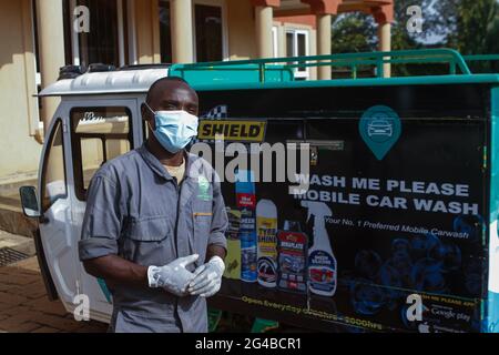 A staff member of Wash Me Please Mobile Carwash prepares to sanitize a clients car after washing it.The wash me please is a Kenyan startup company that offers convenient mobile carwash services from the comfort of your home or workplace as a way of helping fight the spread of Covid-19. Wash me please is detailing and Carwash Company which was started in the beginning of the Covid-19 pandemic. They offer carwash mobile services to clients through a mobile app that clients use to request their service. This service has offered a safe space for women and the elderly who would fear to take their Stock Photo