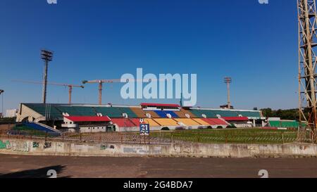 Football stadium in the city park. A green field and stands are visible, painted in different colors. Close-up shot. Aerial photography. Stock Photo