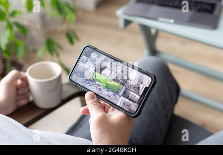person hand holding smartphone with multiple camera views Stock Photo