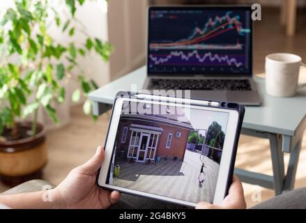 father working at home and monitoring home security camera Stock Photo