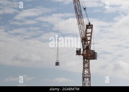 A package hangs on the hook block of a construction crane. Stock Photo