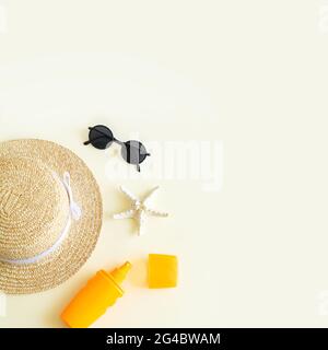Beach accessories flat lay and summer background top view. Sun hat, sunglasses, sunscreen bottle and starfish with copy space Stock Photo