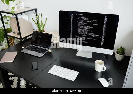 Image of workplace of programmer with computer monitor with software on the table at office Stock Photo