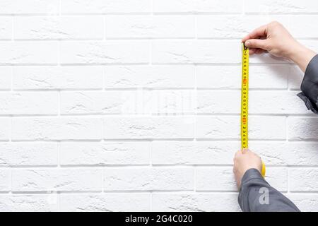 Cropped male using yellow Tape measure copy space Stock Photo
