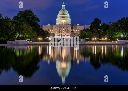 The Capitol and Reflecting Pool - Dusk view of west side of U.S. Capitol Building, with a summer concert at front, reflected in Reflecting Pool, USA. Stock Photo