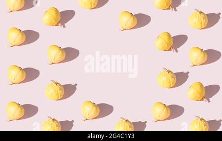 Pattern of decorative pumpkins on a pink background with place for text. Autumn concept. Stock Photo