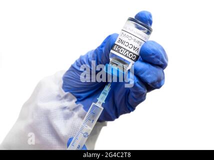 COVID-19 vaccine in doctor hands isolated on white background, nurse holds syringe and coronavirus vaccine vial. Concept of vaccination, immunization, Stock Photo