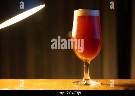 A glass of delicious craft beer served on an authentic beer glass, to be used as a background Stock Photo