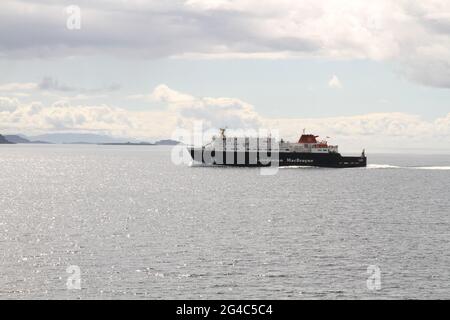 A Caledonian MacBrayne ferry travels across the sea from the Isle of Mull, with white clouds and blue skies. Stock Photo