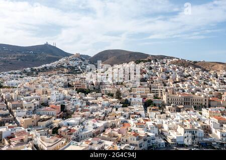 Ermoupolis and Ano Siros town cityscape, Syros island, Greece, aerial drone view. The Catholic cathedral of Saint George and the orthodox church of Re Stock Photo