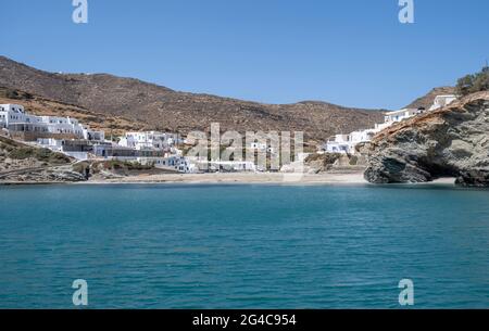 Summer vacations at a Greek island, Cyclades, Greece. Swimming at Folegandros sandy beach Agkali, clear turquoise water and blue sky background. White Stock Photo