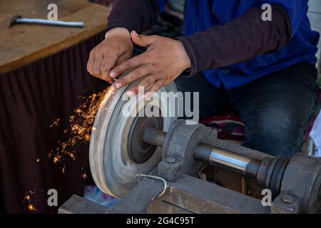 Sparks grinding wheel while knife sharpening Stock Photo