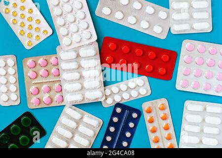 Different pills, tablets, capsule medicines blister packs, on blue background. Top view. Pharmaceutical industry. Health care concept Stock Photo