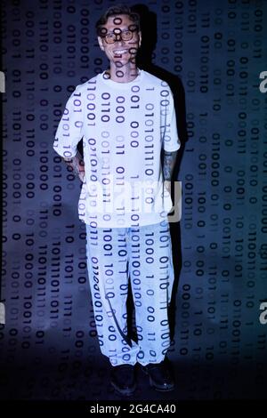 Portrait of young computer hacker smiling at camera while standing in cyberspace centre Stock Photo