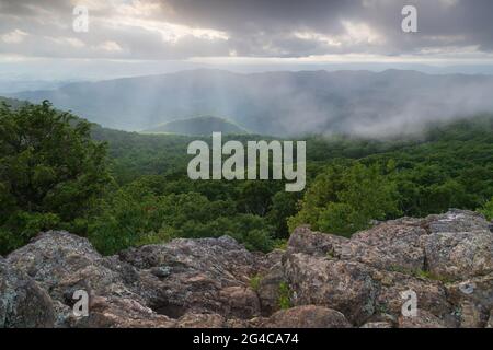 Rays of light from the setting sun shine through the clouds over the Appalachian Mountains in Shenandoah National Park, Virginia, United States Stock Photo