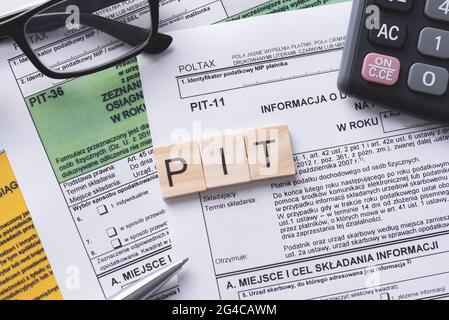 Tax income concept with polish tax forms and PIT word from tiles, means personal tax income in Poland Stock Photo
