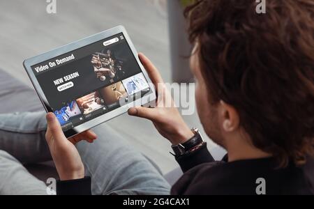 Video on demand, movie streaming, man with tablet using video service Stock Photo