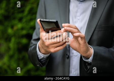 Man in a gray suit with a smartphone. Stock Photo