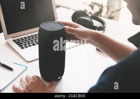 Man using smart speaker. Modern smart home device, intelligent assistant appliance Stock Photo