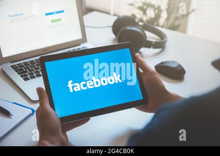 Wroclaw, Poland - JUN 17, 2021: Man using Facebook appication on Huawei MediaPad T3 tablet. Facebook is most popular social media service. Stock Photo