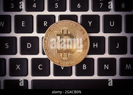 Golden coins with bitcoin symbol on laptop keyboard Stock Photo