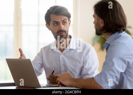 Confident businessman discussing project strategy with business partner Stock Photo