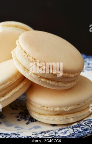 A close up stack of french macarons on a vintage blue and white plate Stock Photo