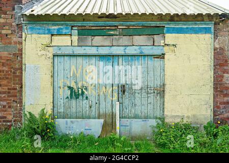 Blue painted wooden doors to building in back lane Stock Photo