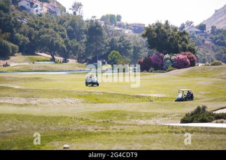 Golf course - green loan with golf carts, bridges, landscaping, clubs and golfers. Stock Photo