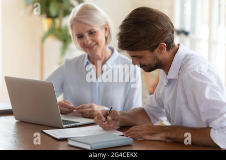 Client signing contract with middle aged manager after successful negotiation Stock Photo