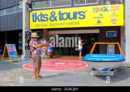 Tourist take picture in front of a tourist tour agency in Cancun Mexico. The Mexican tourist city has been highly impacted by the smaller number of tourists arriving here because of the Covid-19 restrictions around the world, June 2021 Stock Photo