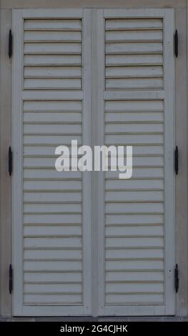 Wooden shutters and a window with closed shutters. Bright old fashioned vintage. Stock Photo