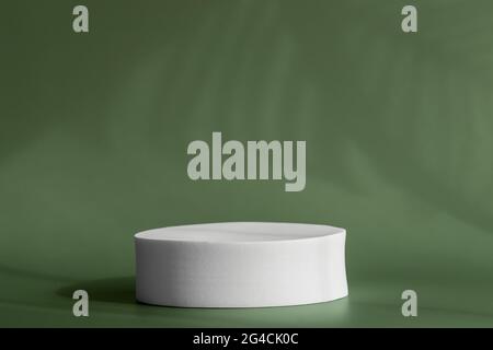 Round pedestal podium for packaging presentation on backdrop with palm leaves shadows from window. Circle platform stage for cosmetic products with Stock Photo