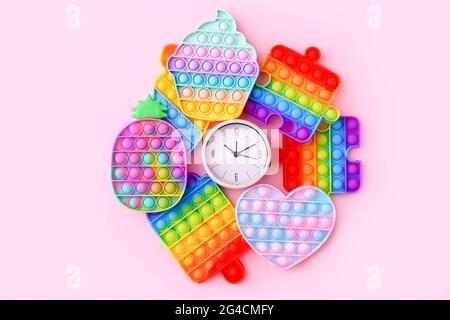 Colorful antistress sensory toys with clock on pink background Stock Photo