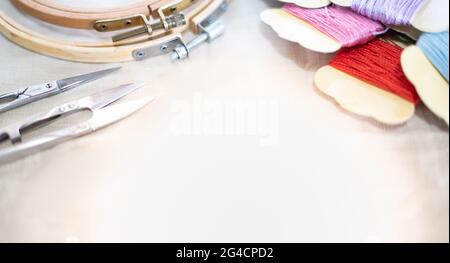 Selective focus of The tailor's workplace with threads, scissors, wood frame, spools, fabric put on white background top view space for text. Stock Photo