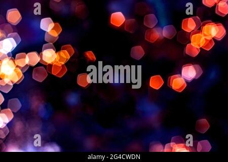 Blurred lights abstract background in the night, defocused dark glowing bokeh backdrop, magical illuminated sparkle pattern. Stock Photo