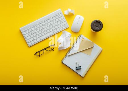 Work space desk layout with note keyboard coffee cup glasses bright color yellow background. Modern office desk work space flat lay composition. White Stock Photo