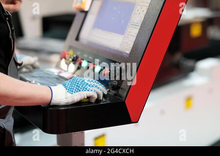 Worker at the controls of laser cutting machine. Selective focus. Stock Photo