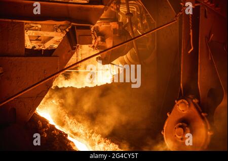 The process of tapping molten metal and slag from a blast furnace. Stock Photo