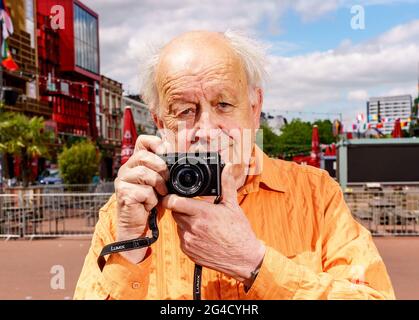 Hamburg, Germany. 15th June, 2021. Günter Zint, neighborhood legend and photographer, holds his camera in his hands on Hamburg's Reeperbahn. Credit: Axel Heimken/dpa/Alamy Live News Stock Photo