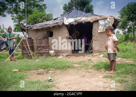Poor Indian kid standing at the door of a mud house in the rural area of uttarakhand, India Stock Photo