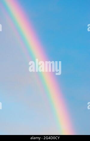 Rainbow in blue with clouds sky background with copy space during sunset Stock Photo