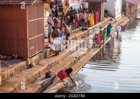 Indian worshippers performing their daily ablutions at the spiritual, holy sacred Koti Tirtha water tank at Gokarna, Karnataka, India Stock Photo