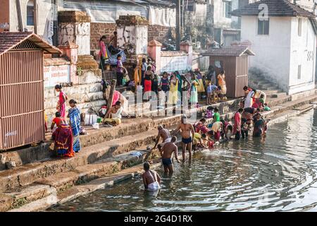 Indian worshippers performing their daily ablutions at the spiritual, holy sacred Koti Tirtha water tank at Gokarna, Karnataka, India Stock Photo