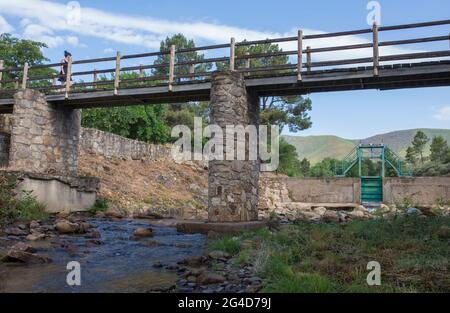 Visitor woman over Acebo natural swimming pool bridge. Sierra de Gata hills. Caceres, Extremadura, Spain Stock Photo